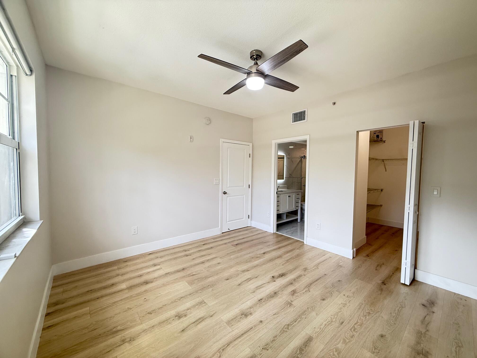 5860 West Sample Road, Unit 202 Coral Springs, FL 33067 - Photo 16 of 26 a view of empty room with wooden floor and window