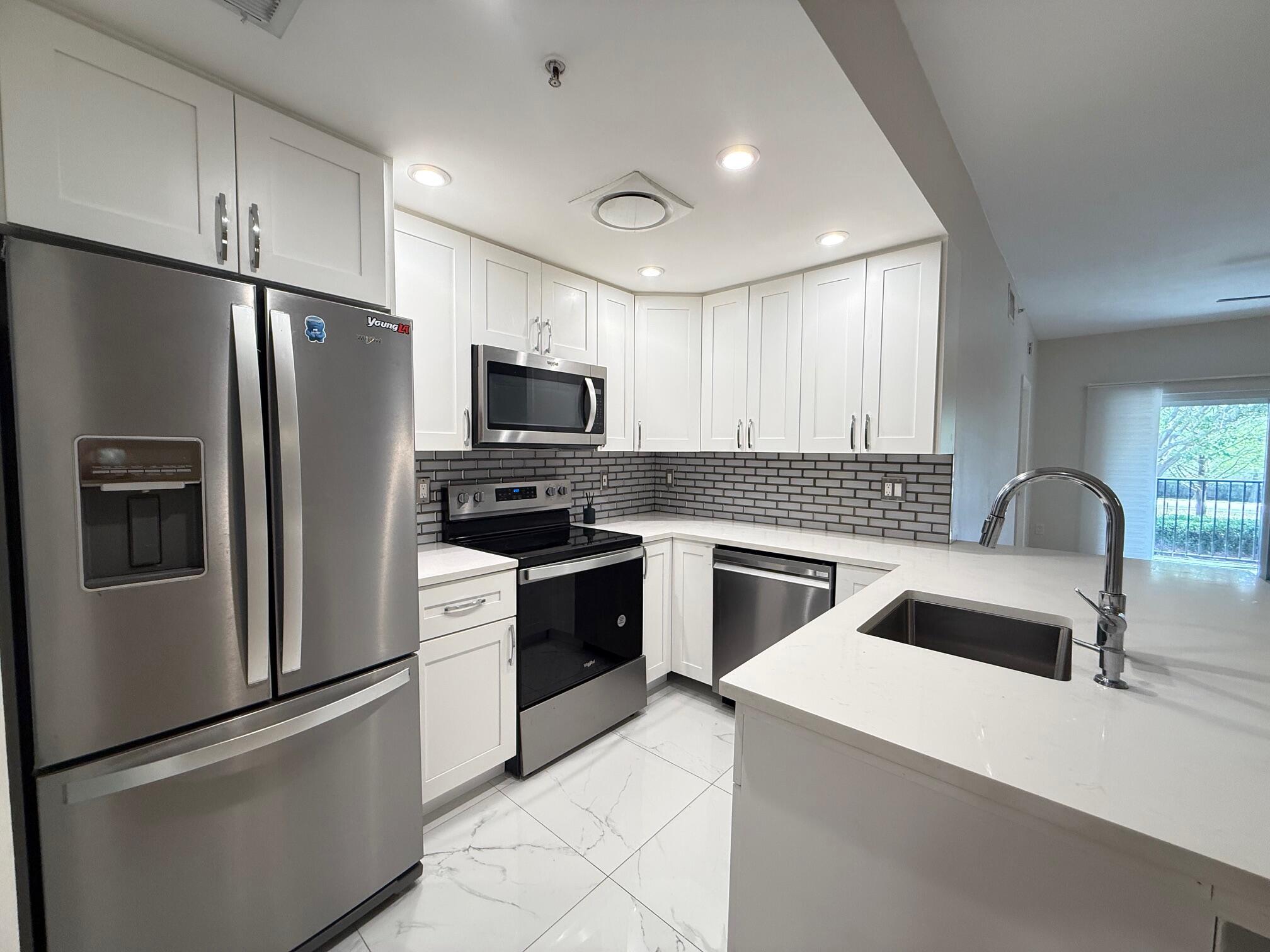 5860 West Sample Road, Unit 202 Coral Springs, FL 33067 - Photo 3 of 26 a kitchen with a refrigerator stove and sink