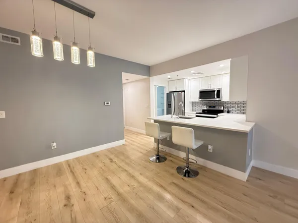 a room with table chairs and appliances