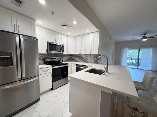 a kitchen with a sink a oven a refrigerator and a oven