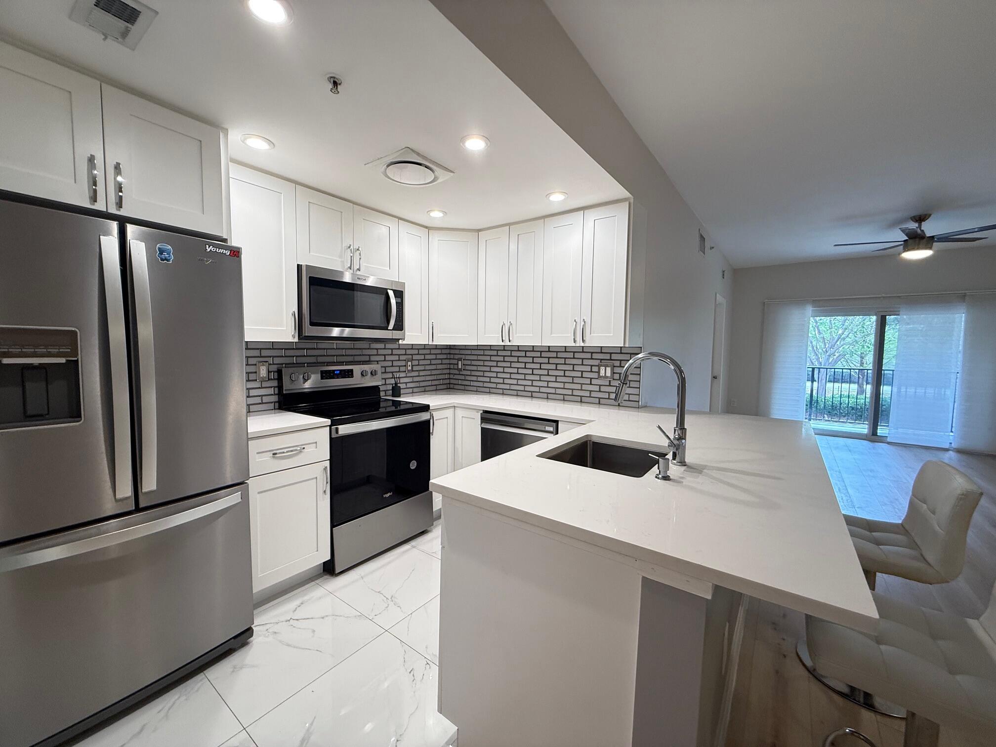 5860 West Sample Road, Unit 202 Coral Springs, FL 33067 - Photo 5 of 26 a kitchen with a sink a oven a refrigerator and a oven