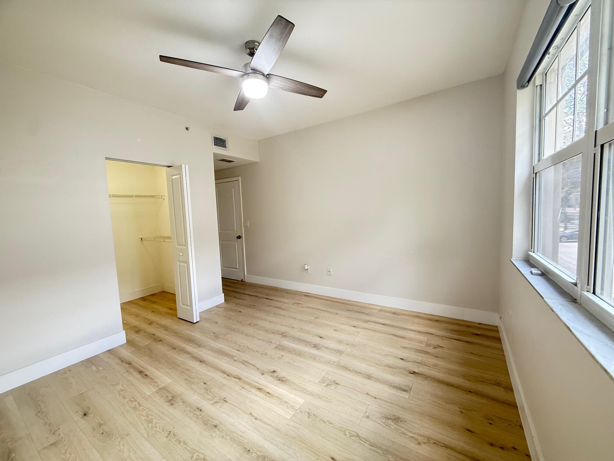 5860 West Sample Road, Unit 202 Coral Springs, FL 33067 - Photo 9 of 26 an empty room with wooden floor and windows