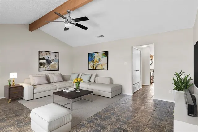 an empty room with a ceiling fan and carpet