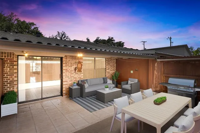 a view of a patio with couches and table and chairs with wooden floor and fence