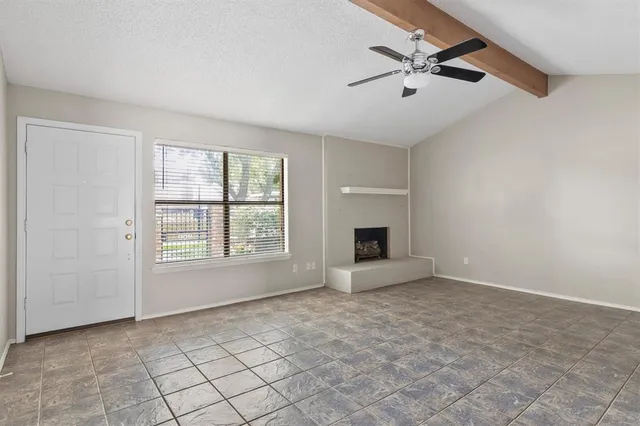an empty room with windows and ceiling fan