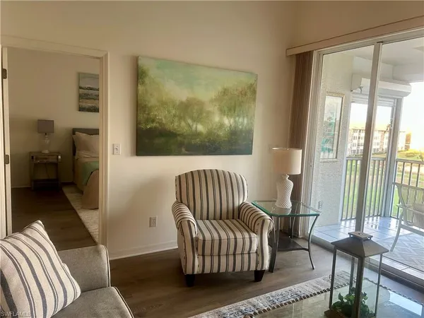 a living room with furniture and a floor to ceiling window