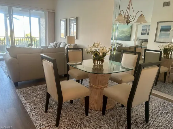 a view of a dining room with furniture a chandelier and wooden floor