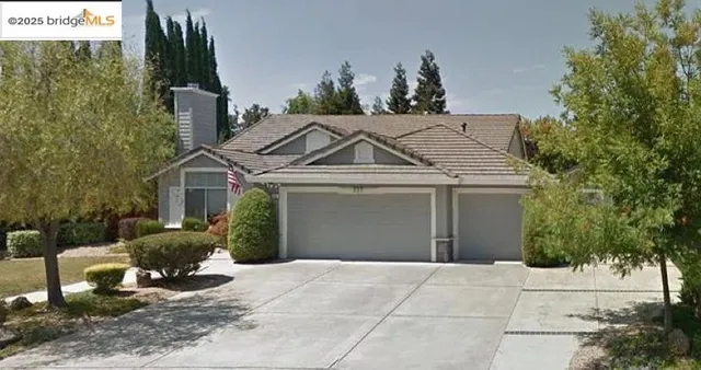 a view of a house with a yard and potted plants