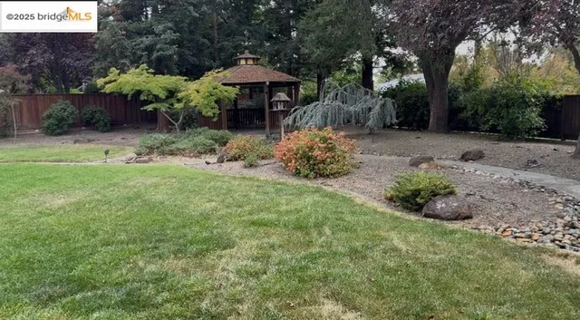 a backyard of a house with table and chairs under an umbrella