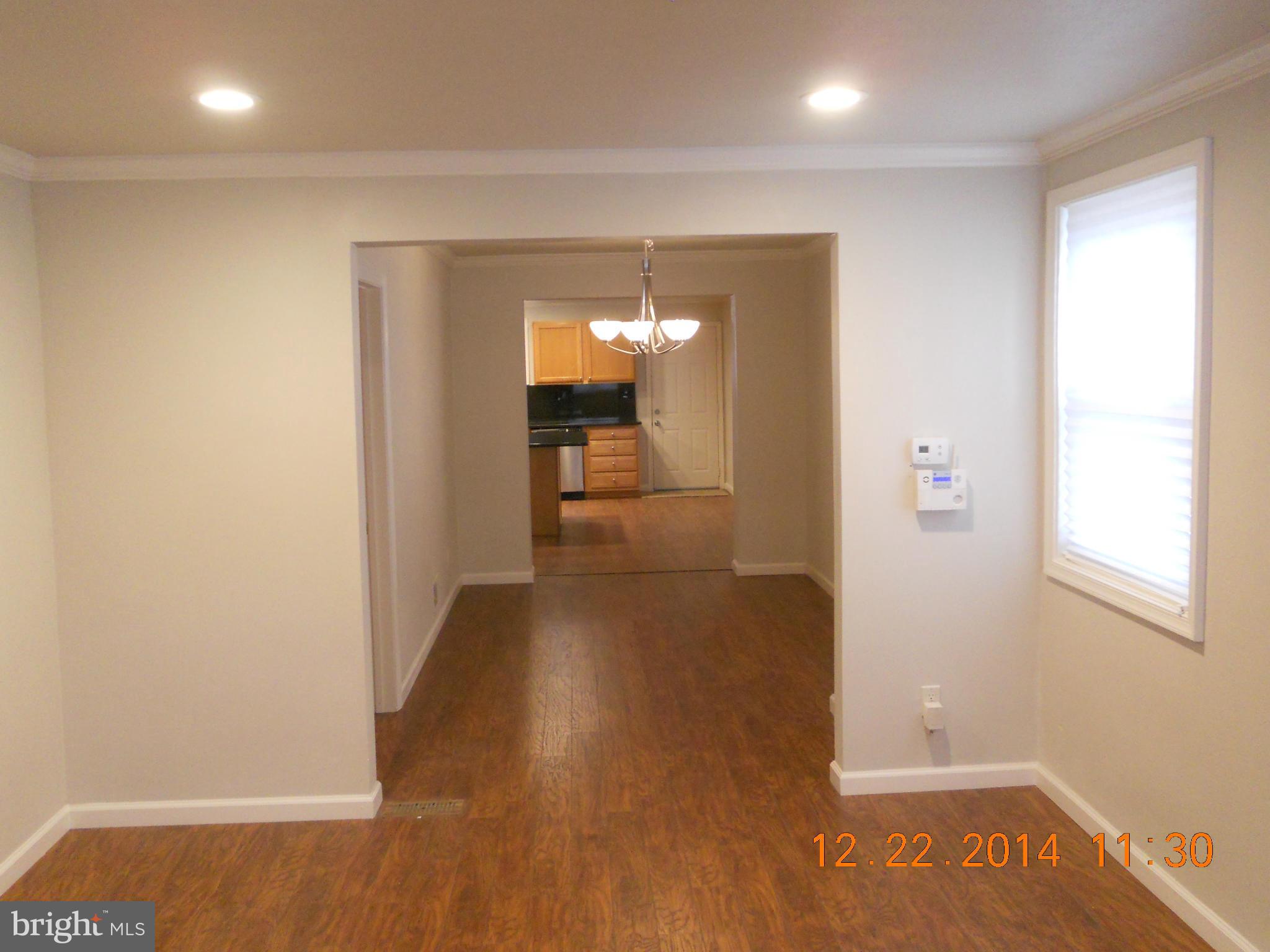 937 Coleridge Road Baltimore, MD 21229 - Photo 6 of 16 a view of a hallway with wooden floor and a bathroom