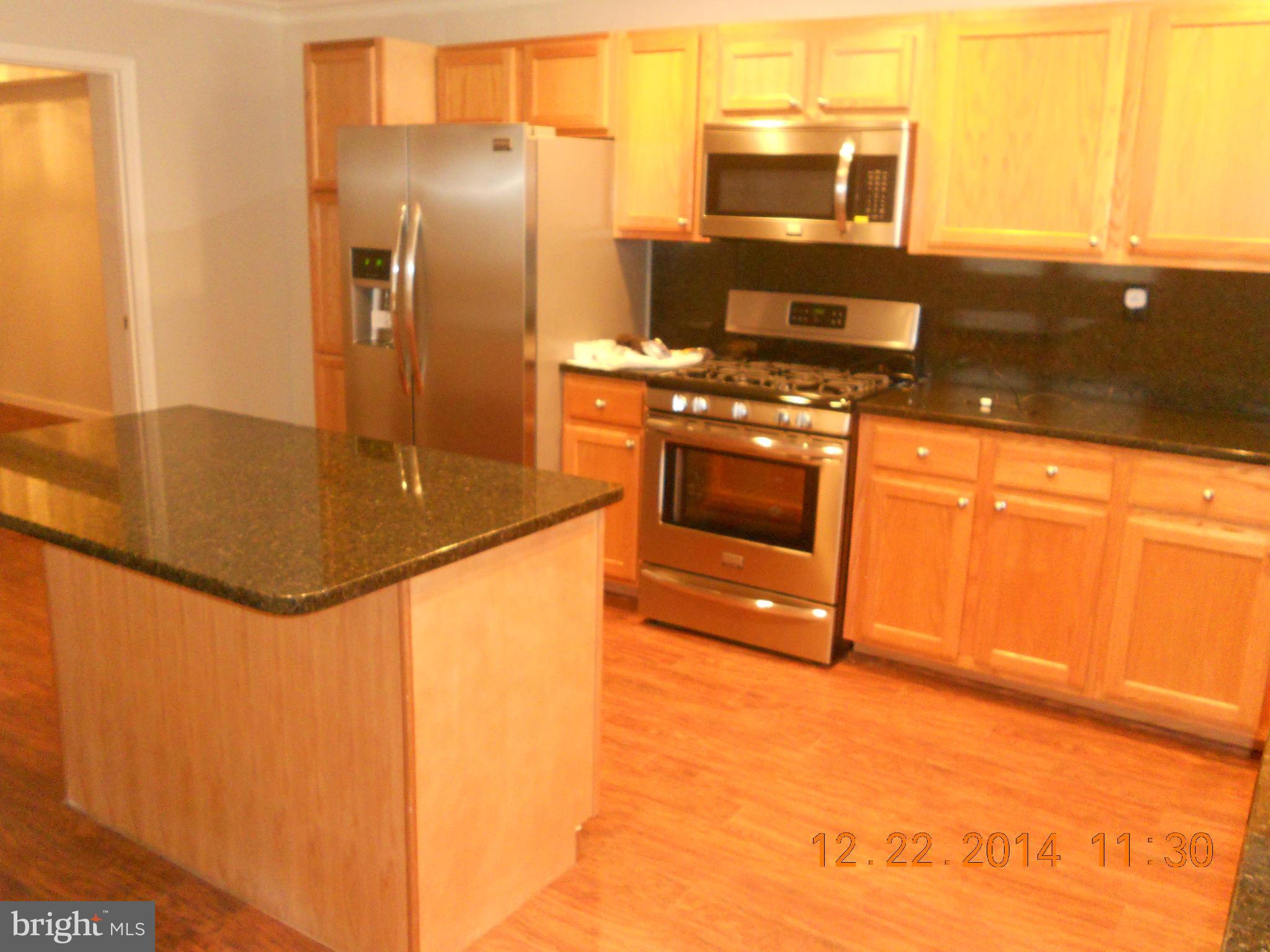 937 Coleridge Road Baltimore, MD 21229 - Photo 8 of 16 a kitchen with stainless steel appliances granite countertop a stove a sink and a refrigerator