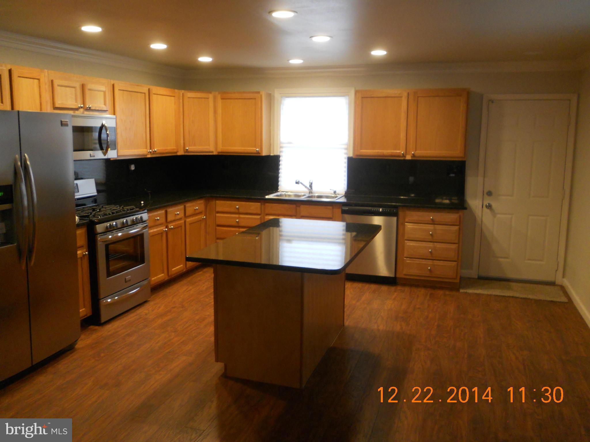937 Coleridge Road Baltimore, MD 21229 - Photo 10 of 16 a kitchen with stainless steel appliances granite countertop a stove top oven a sink and a microwave