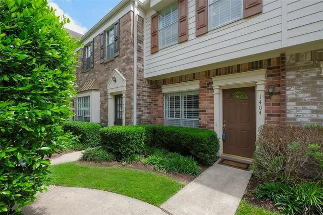 front view of a brick house with a yard
