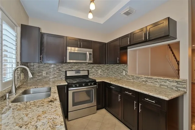 a kitchen with granite countertop stainless steel appliances and sink
