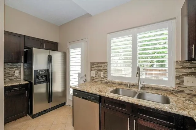 a kitchen with granite countertop a refrigerator and a sink
