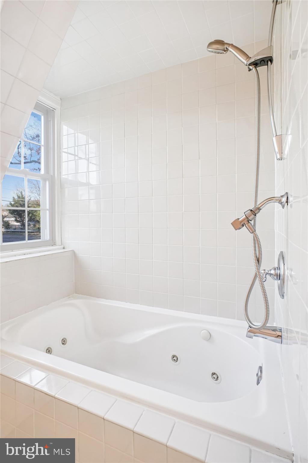 6022 Valley View Drive Alexandria, VA 22310 - Photo 19 of 50 a bathroom with a bathtub a window and a shower
