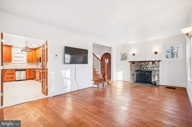a view of a livingroom with wooden floor and a fireplace
