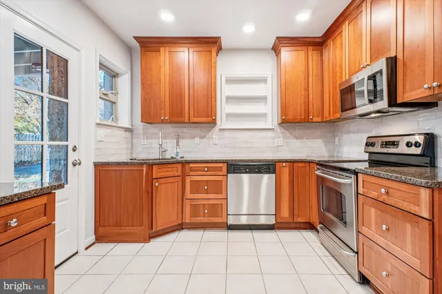 a kitchen with stainless steel appliances granite countertop wooden cabinets a sink and dishwasher
