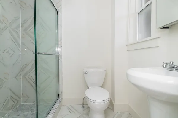 a bathroom with a sink a toilet and shower