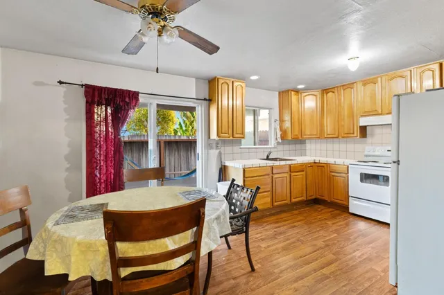 a kitchen with a table chairs refrigerator and cabinets