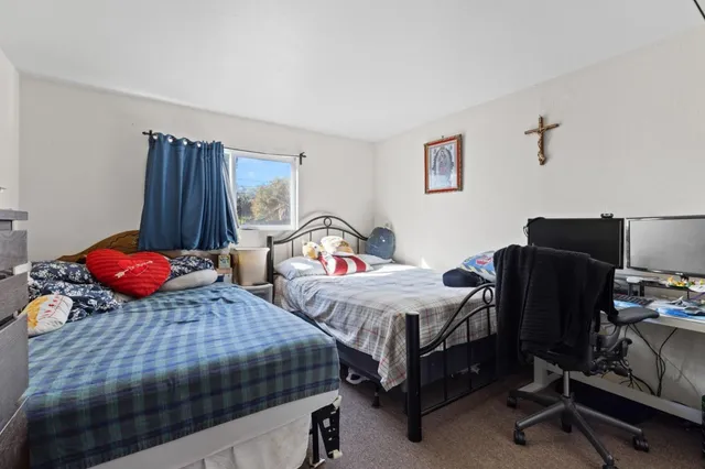 a bedroom with two beds and a desk