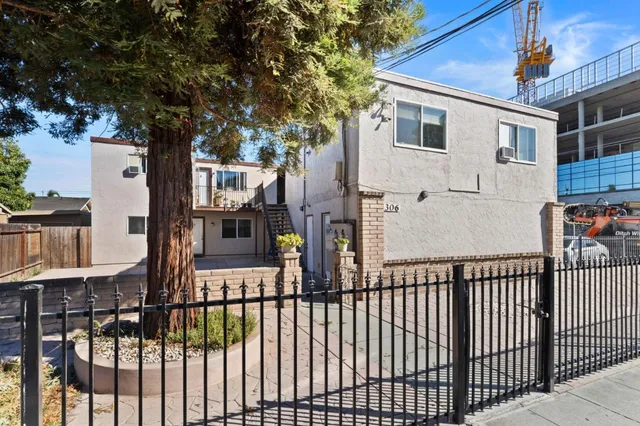 a view of a white house with iron fence