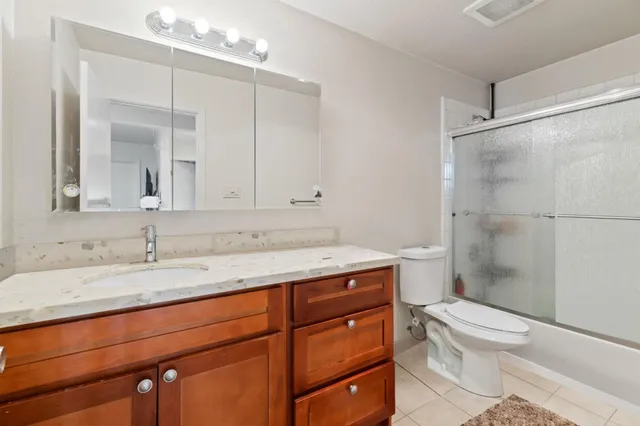 a spacious bathroom with a granite countertop sink and a mirror