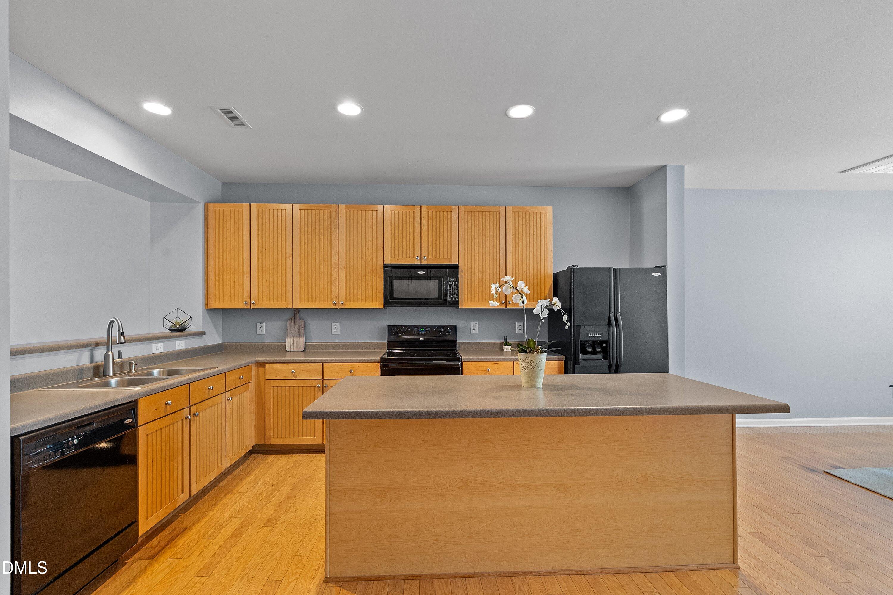 3114 Rapid Falls Road Cary, NC 27519 - Photo 7 of 37 a kitchen with stainless steel appliances granite countertop a sink a stove counter space and cabinets
