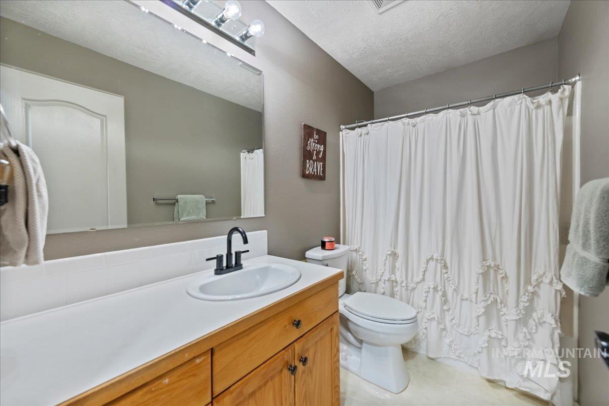 3411 North Summercrest Way Meridian, ID 83646 - Photo 20 of 30 Full bath featuring vanity, a textured ceiling, and a shower with curtain