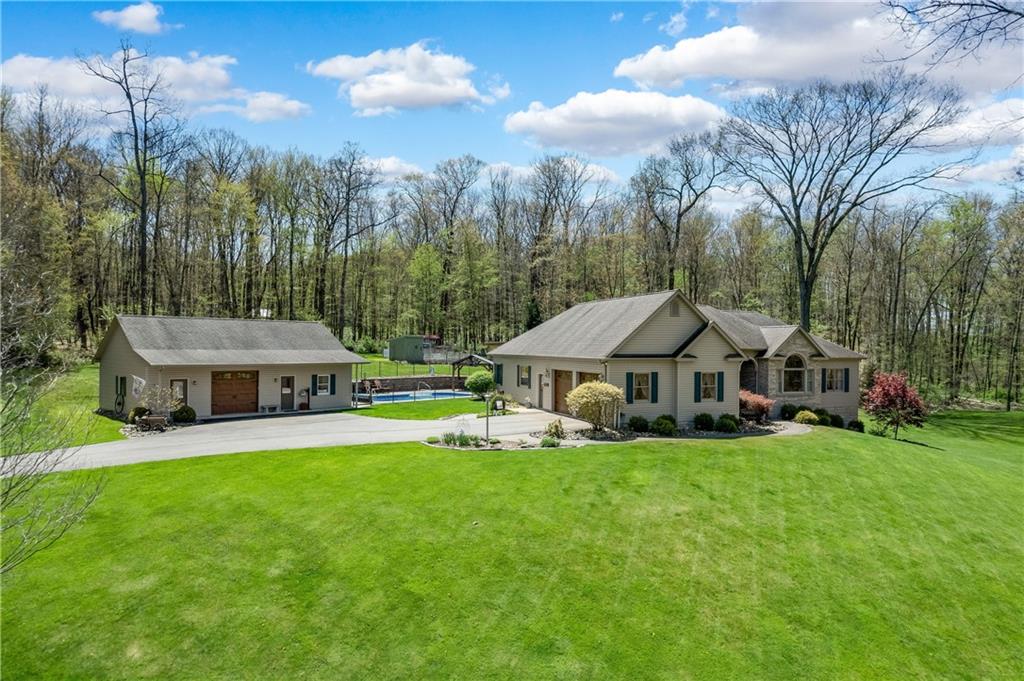 a view of a house with a big yard and large trees