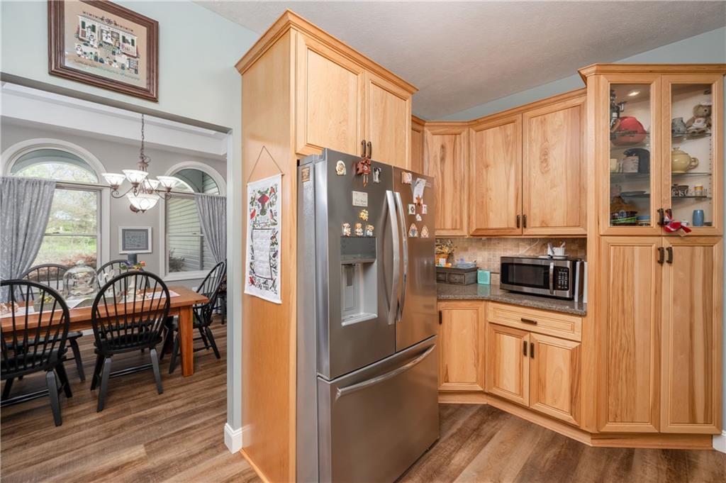 825 Whitestown Road Butler, PA 16001 - Photo 18 of 49 a kitchen with stainless steel appliances granite countertop a refrigerator a stove and a dining table with wooden floor