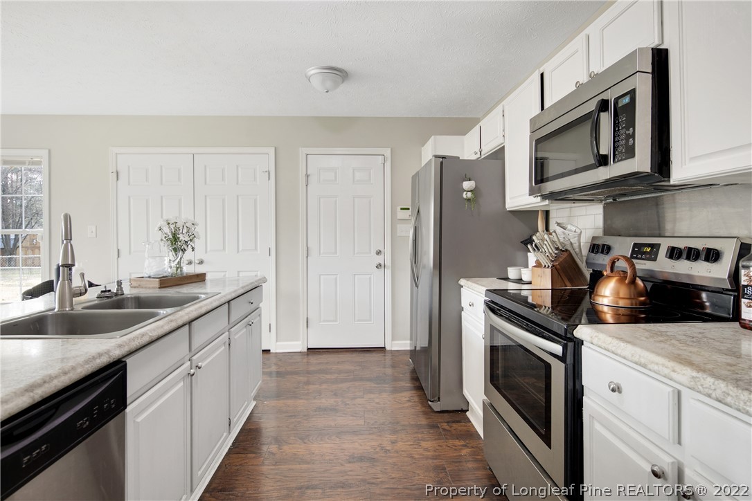 7096 Rockfish Road Raeford, NC 28376 - Photo 13 of 40 a kitchen with stainless steel appliances granite countertop a sink stove and refrigerator