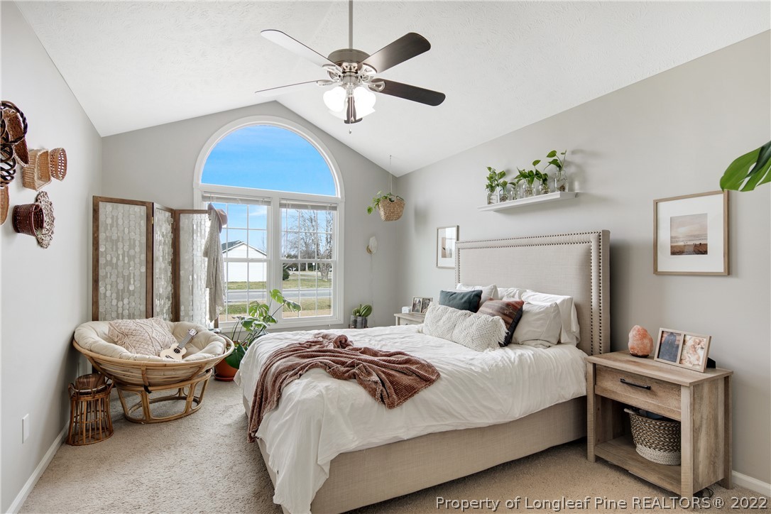 7096 Rockfish Road Raeford, NC 28376 - Photo 22 of 40 a bedroom with a bed and a chandelier