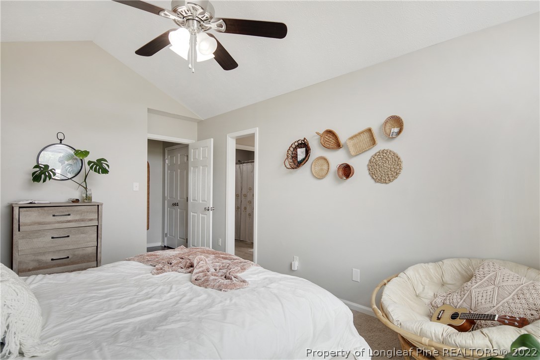 7096 Rockfish Road Raeford, NC 28376 - Photo 24 of 40 a bedroom with a bed and a chandelier