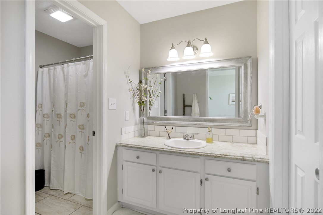 7096 Rockfish Road Raeford, NC 28376 - Photo 26 of 40 a bathroom with a sink double vanity and a mirror