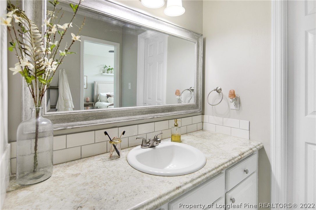 7096 Rockfish Road Raeford, NC 28376 - Photo 27 of 40 a bathroom with a granite countertop sink and a mirror
