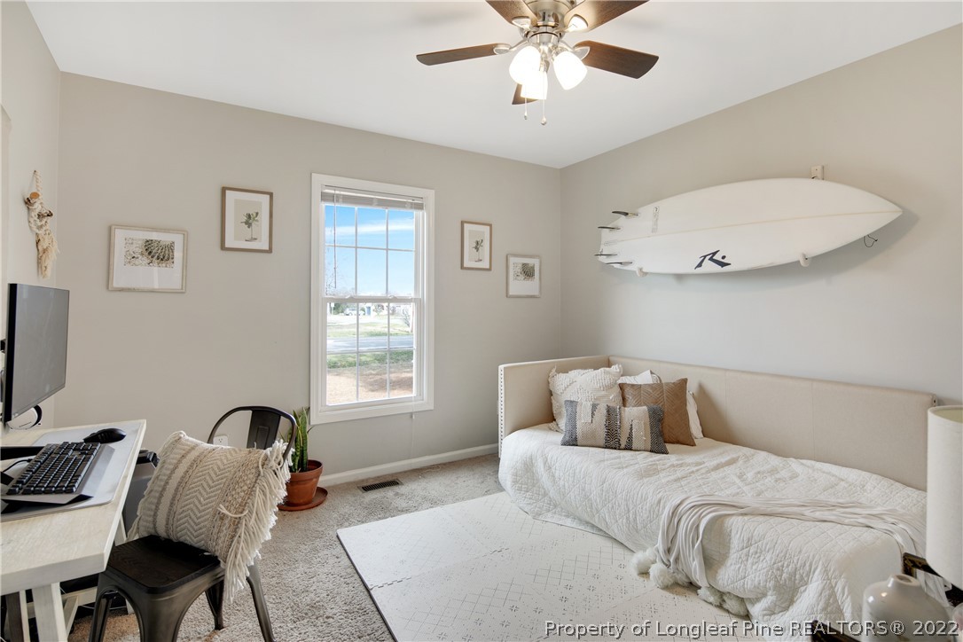 7096 Rockfish Road Raeford, NC 28376 - Photo 29 of 40 a bedroom with a bed and a chandelier