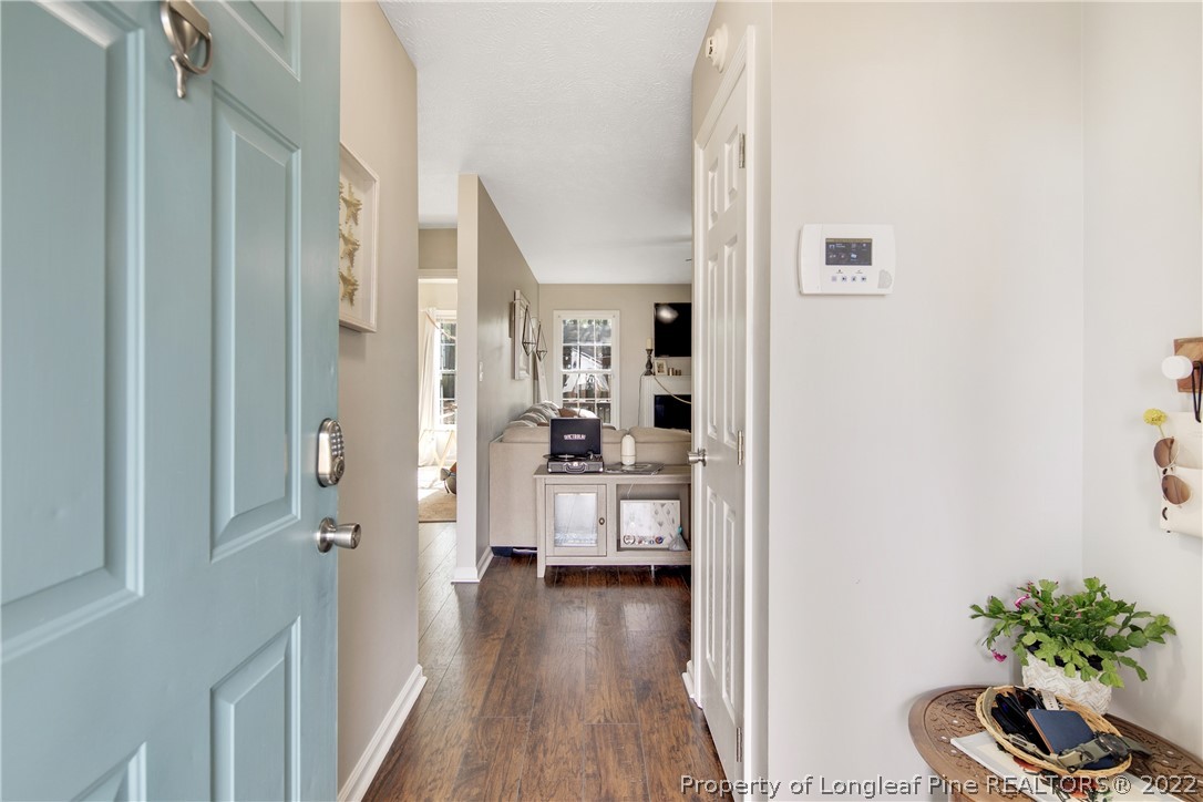 7096 Rockfish Road Raeford, NC 28376 - Photo 5 of 40 a view of a hallway with wooden floor a chandelier and a living room