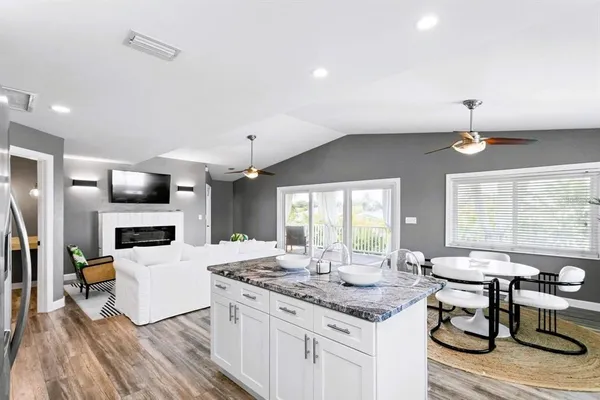a kitchen with stainless steel appliances granite countertop a sink a stove and microwave