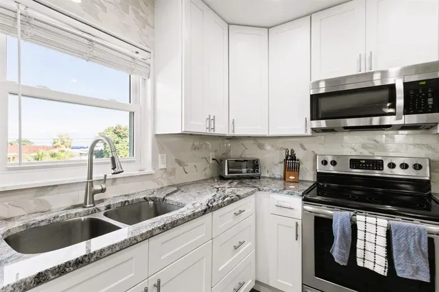 a view of an empty room with wooden floor and windows