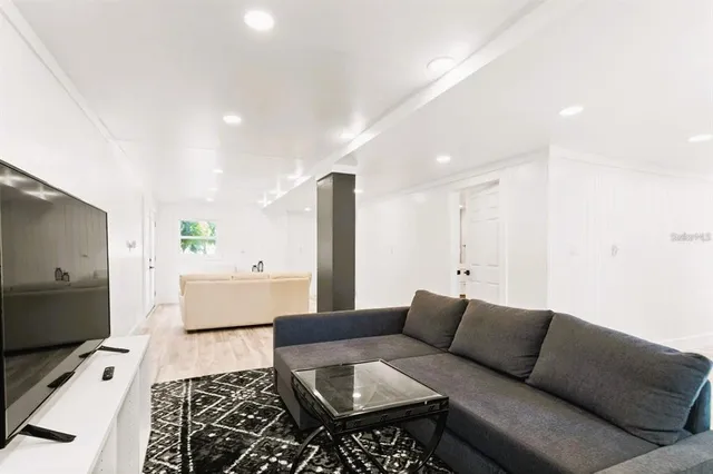 a living room with furniture and a wooden floor