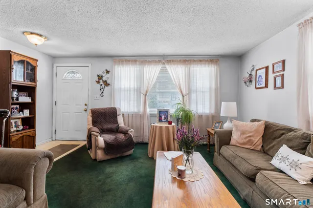 a living room with furniture wooden floor and a large window