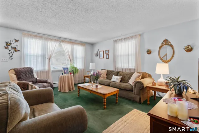 a kitchen with stainless steel appliances granite countertop a sink a stove a dining table with chairs