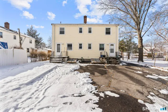 a view of a white house with a snow on the road