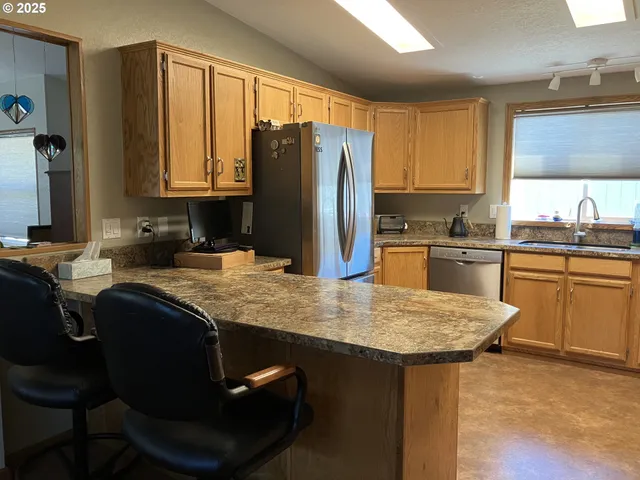 a kitchen with a sink a stove a refrigerator and cabinets