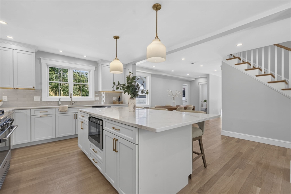 20 Saltonstall Road Medford, MA 02155 - Photo 14 of 41 a kitchen with stainless steel appliances granite countertop a sink a stove a refrigerator and island with wooden floor