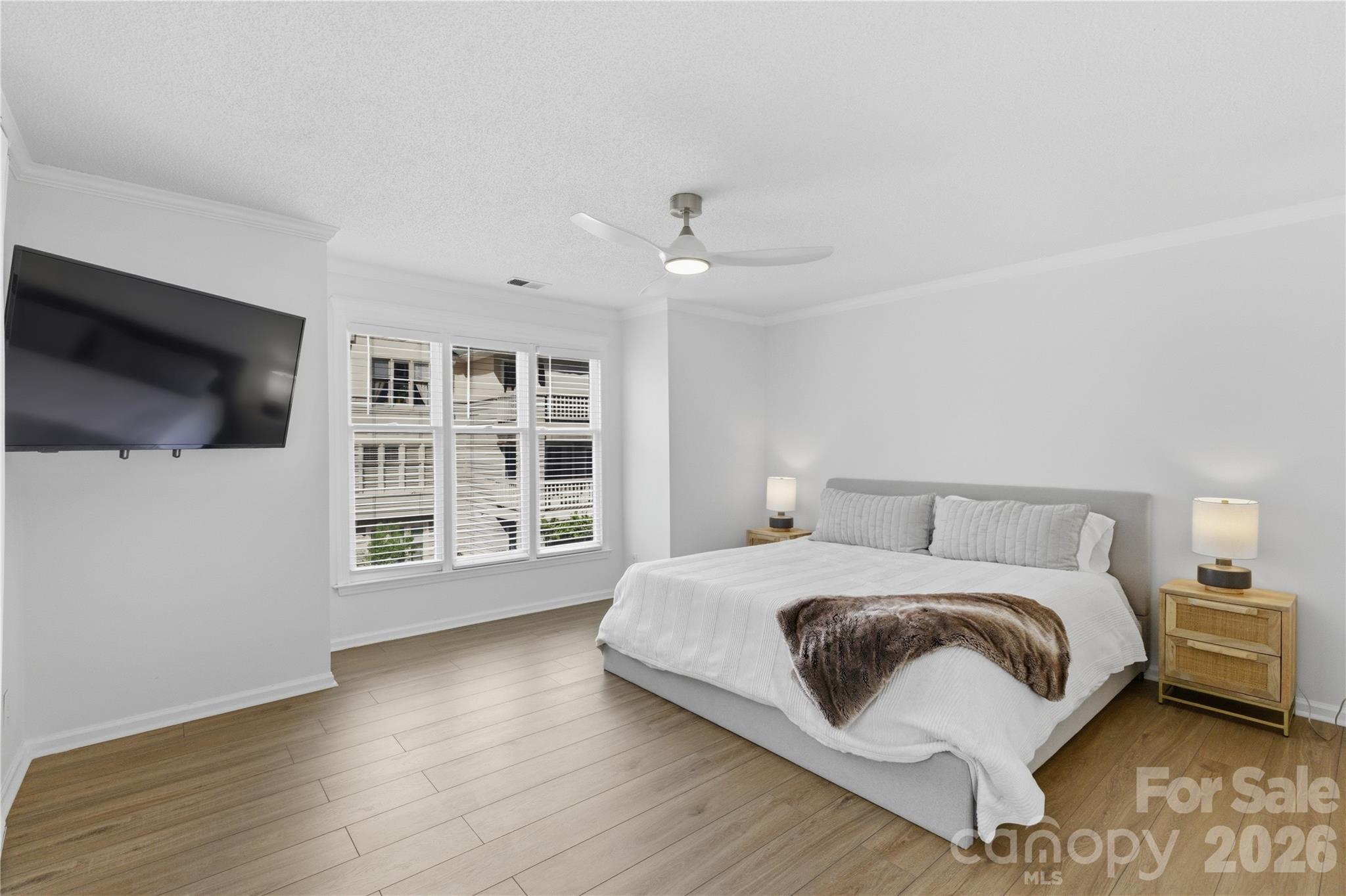 308 Queens Road, Unit 32 Charlotte, NC 28204 - Photo 13 of 30 a bedroom with a bed a flat screen tv and a large window