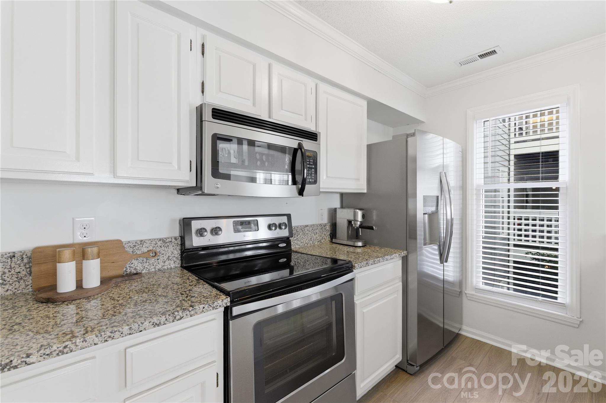 308 Queens Road, Unit 32 Charlotte, NC 28204 - Photo 4 of 30 a kitchen with granite countertop a stove sink and refrigerator