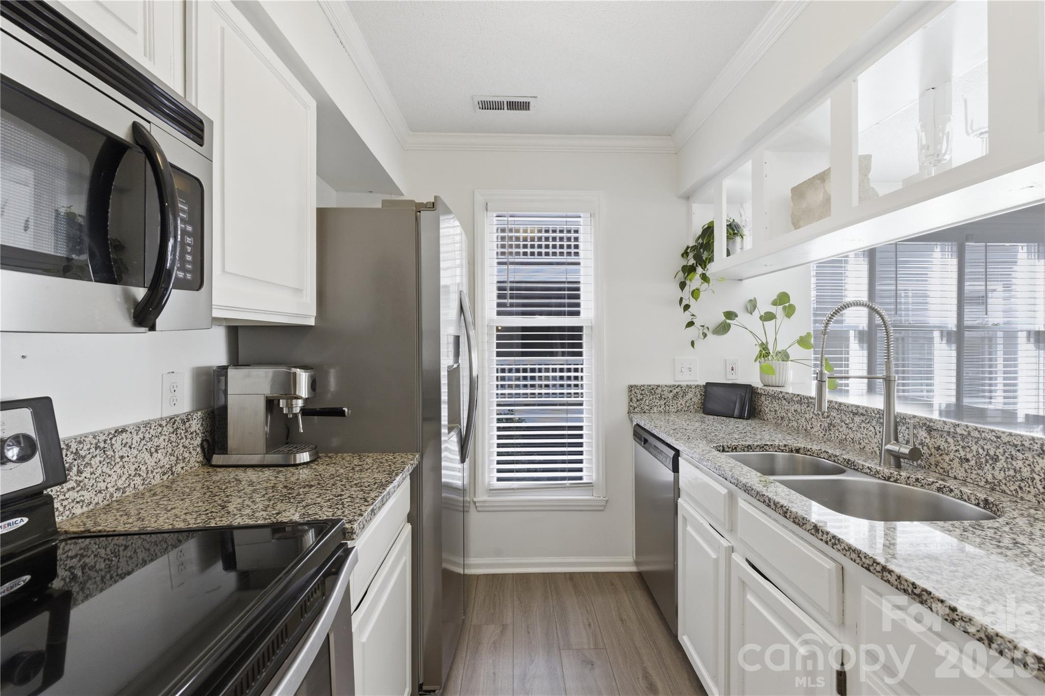308 Queens Road, Unit 32 Charlotte, NC 28204 - Photo 5 of 30 a kitchen with granite countertop stainless steel appliances window a sink and cabinets