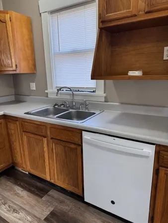 a kitchen with a sink cabinets and wooden floor